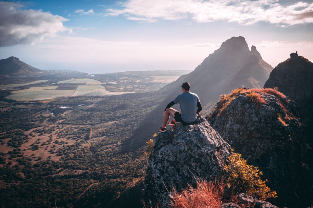 Person sitting on a mountain overlook, representing long-term health goals and personalized care planning.